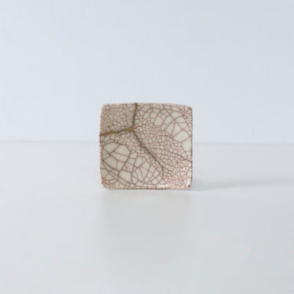 Zijaanzicht van Kintsugi vierkant bord "Vermilion Crackle" 06 tegen een witte achtergrond