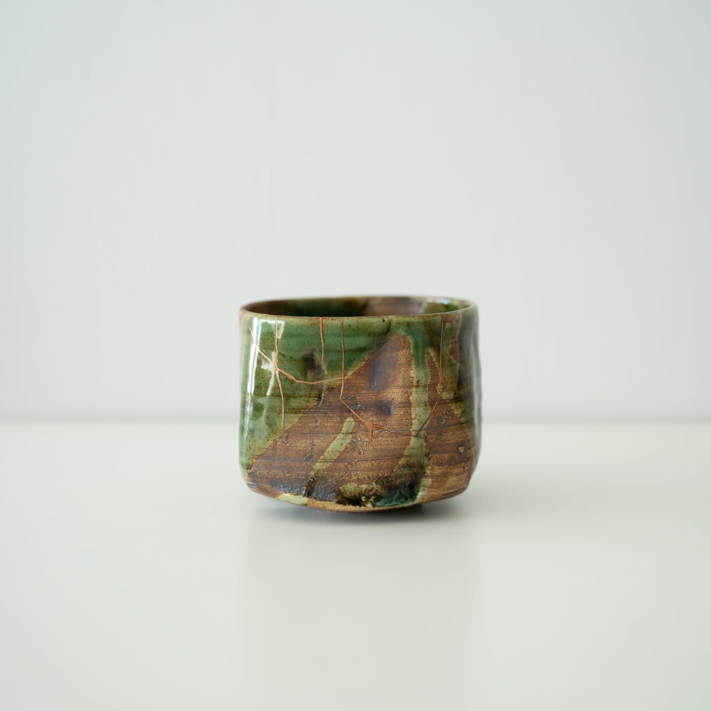 Sidevisning af Kintsugi-tekop "Valley Oribe" på hvid baggrund