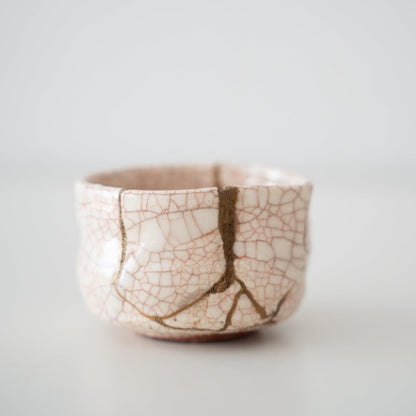 Tæt på siden af Kintsugi-tekop "Vermilion Crackle", der fremhæver de indviklede Kintsugi-reparationer