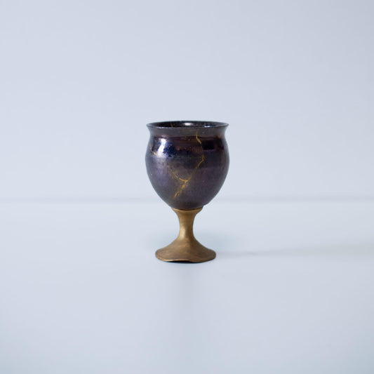Magenta kintsugi wine goblet repaired with Kintsugi, a traditional Japanese technique. 