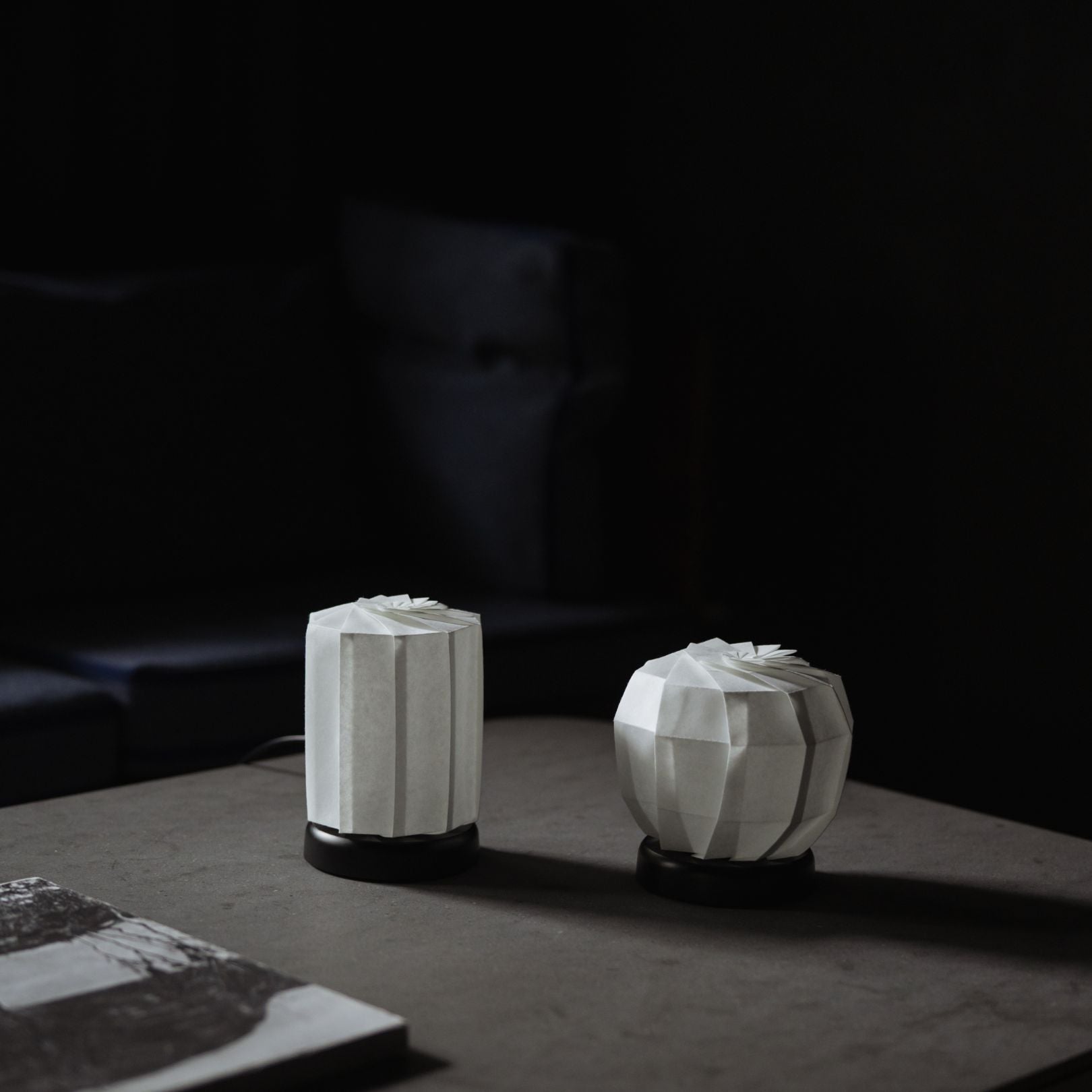 Japanse origami papieren tafellamp op een grijze tafel in een Japandi-kamer