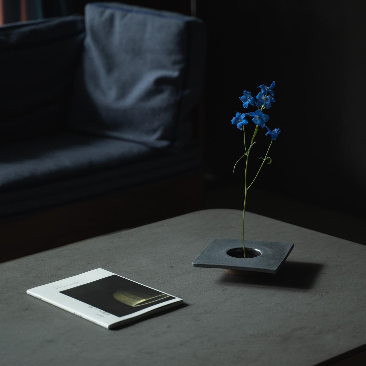 Nærbillede af en minimalistisk jern ikebana-vase, der viser kenzan (blomsterfrosk) til at arrangere blomster.