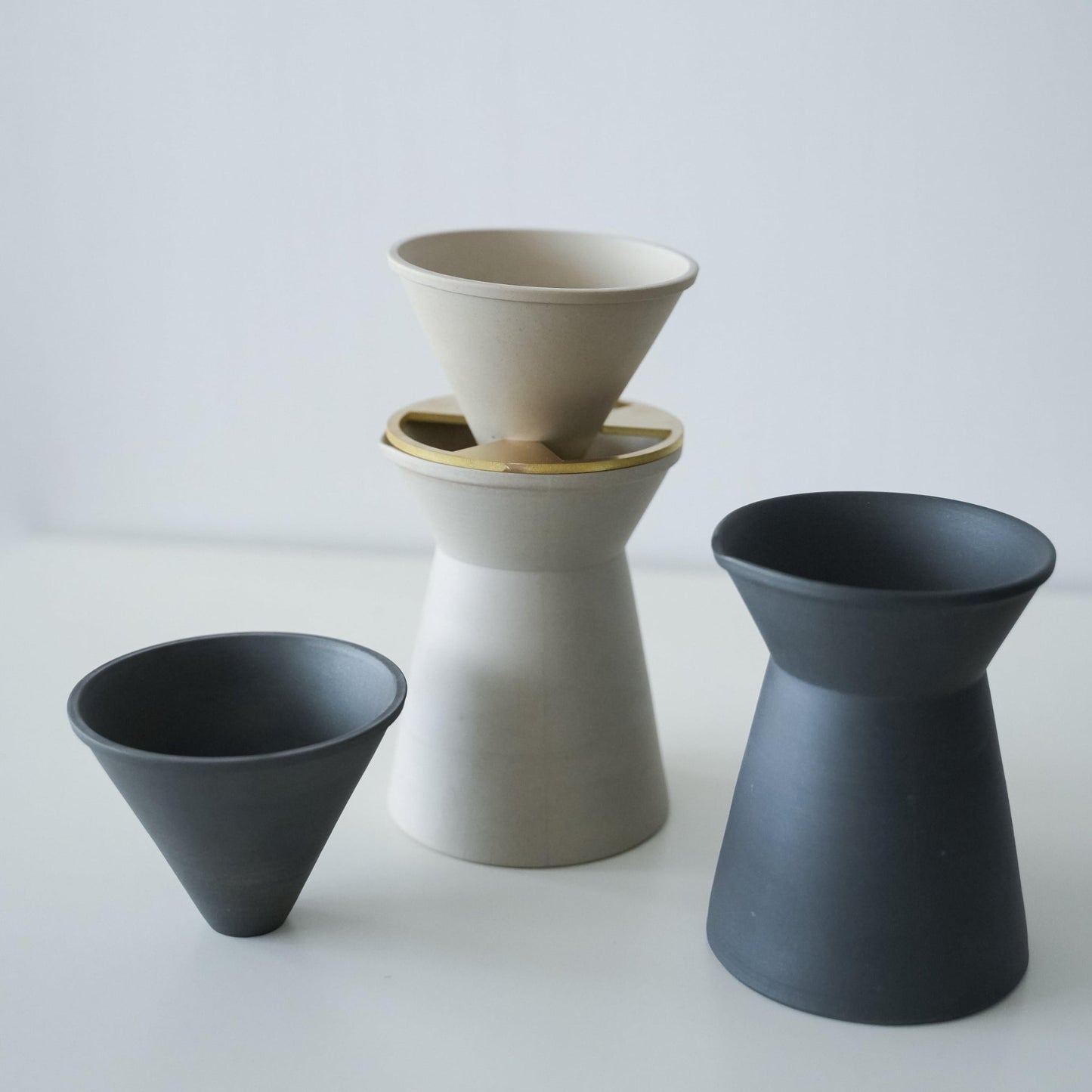 A minimalist white and black coffee server crafted with traditional Japanese Banko-yaki ceramic, featuring a smooth curve and matte finish.