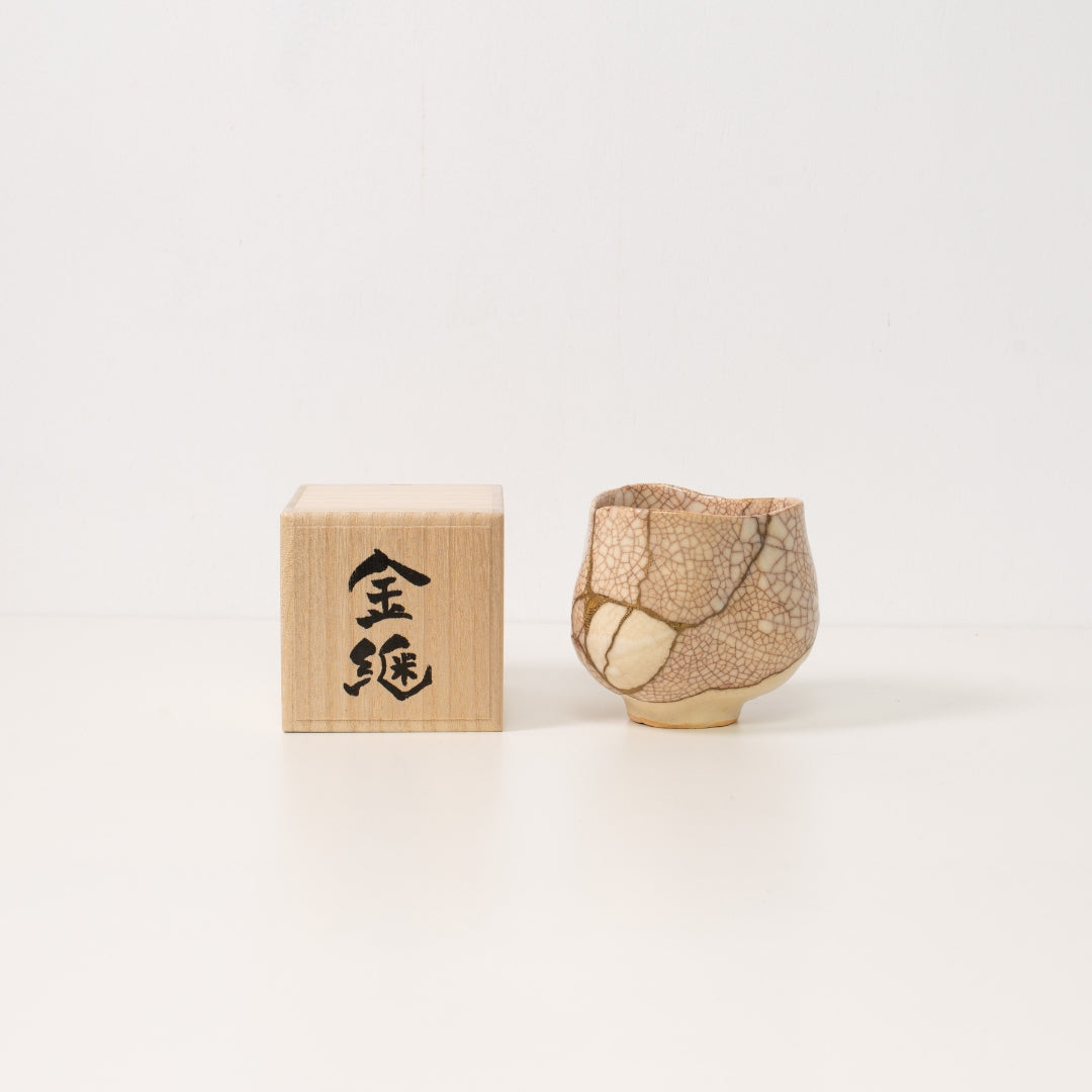 Højt vinkelbillede inde i en hvid krakeleret kintsugi matcha-skål, der afslører dramatiske gyldne reparationer, der legemliggør wabi sabi