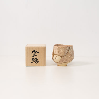 Højt vinkelbillede inde i en hvid krakeleret kintsugi matcha-skål, der afslører dramatiske gyldne reparationer, der legemliggør wabi sabi