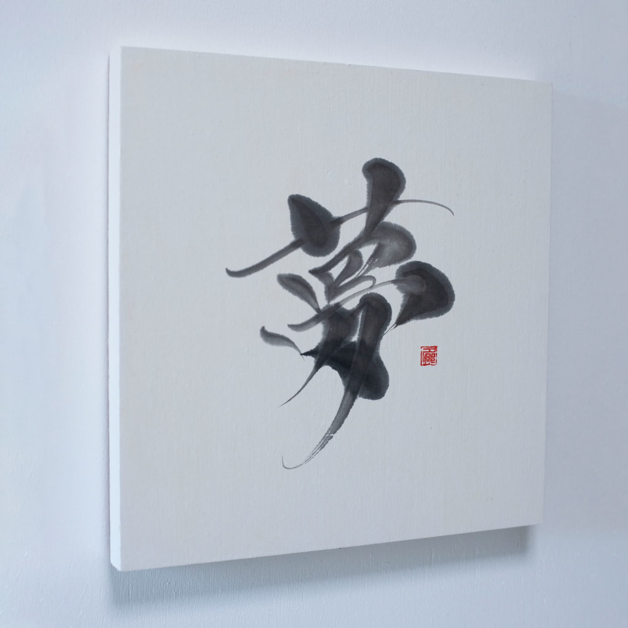 "Een wanddecoratie met '夢' (droom) in Japanse kalligrafie, gemonteerd aan een witte muur." 