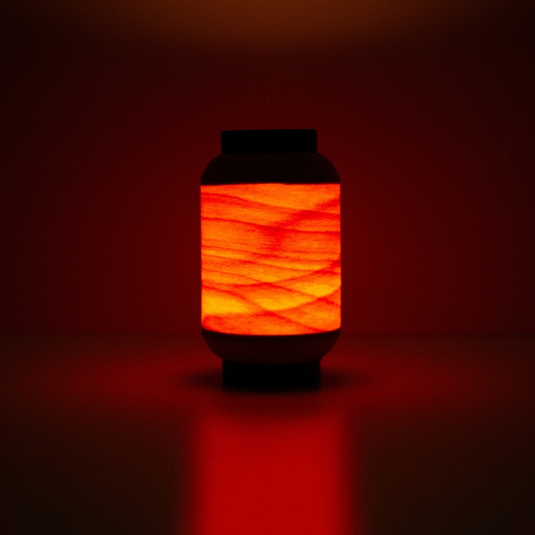 Japanse houten lamp die een warme roodachtige gloed werpt, geïnspireerd op traditionele festival lantaarns.