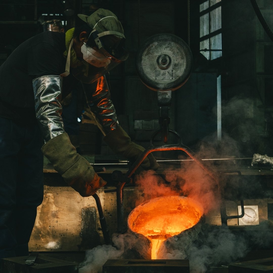 Handwerker gießt geschmolzenes Metall in der Kanamori Alloy Gießerei und fertigt Kenzan und japanische Blumenvasen