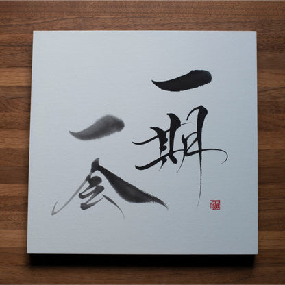 Vue_du_dessus_d_un_panneau_de_calligraphie_avec_Ichigo_Ichie_sur_une_table_en_bois
