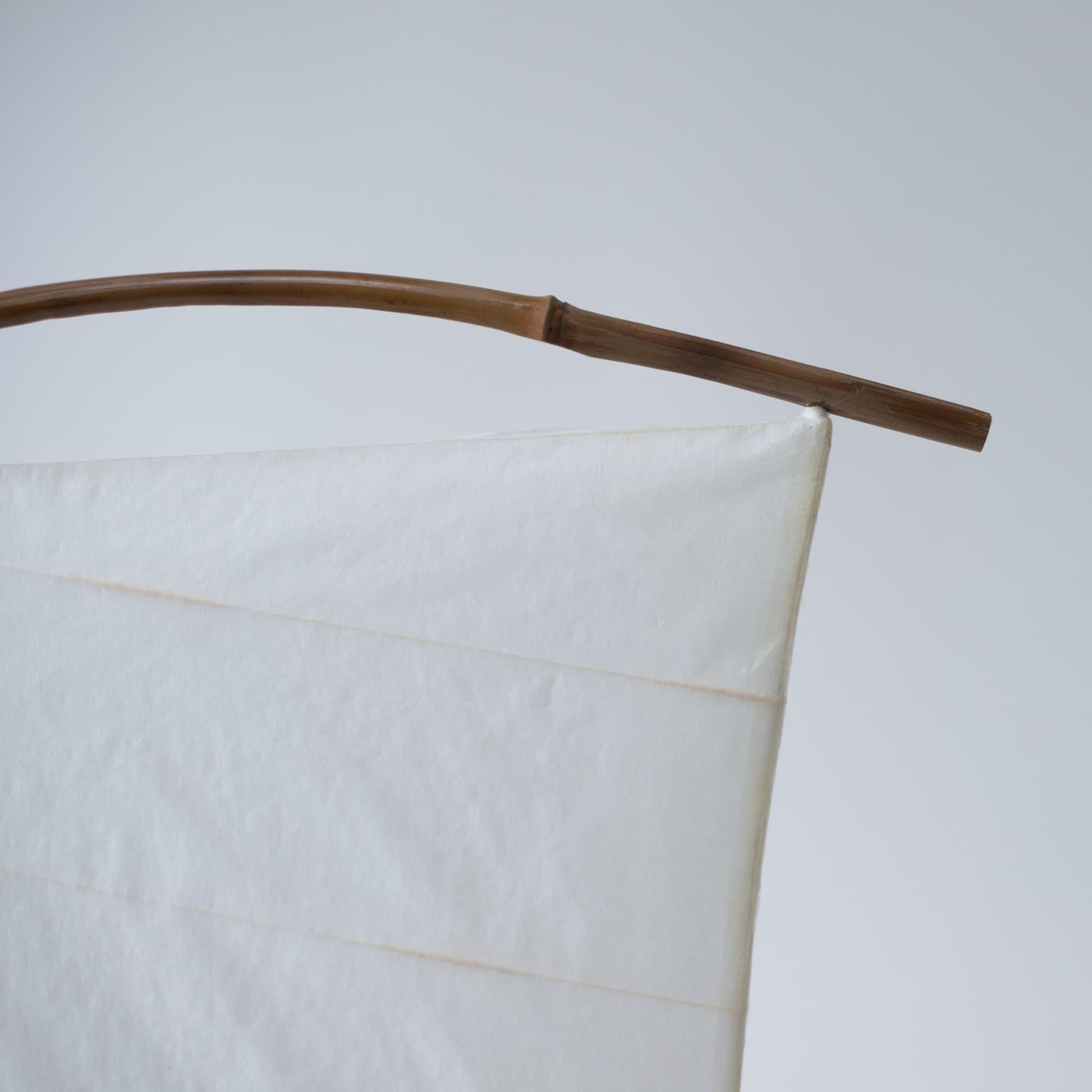 Gros plan sur le dessus de la lampe sur pied japonaise en papier « NOW » sur fond blanc