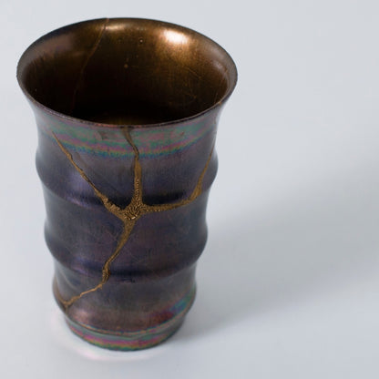 Topudsigt over magenta kintsugi-keramik med guldfarvede reparationslinjer | wabi sabi kunststil