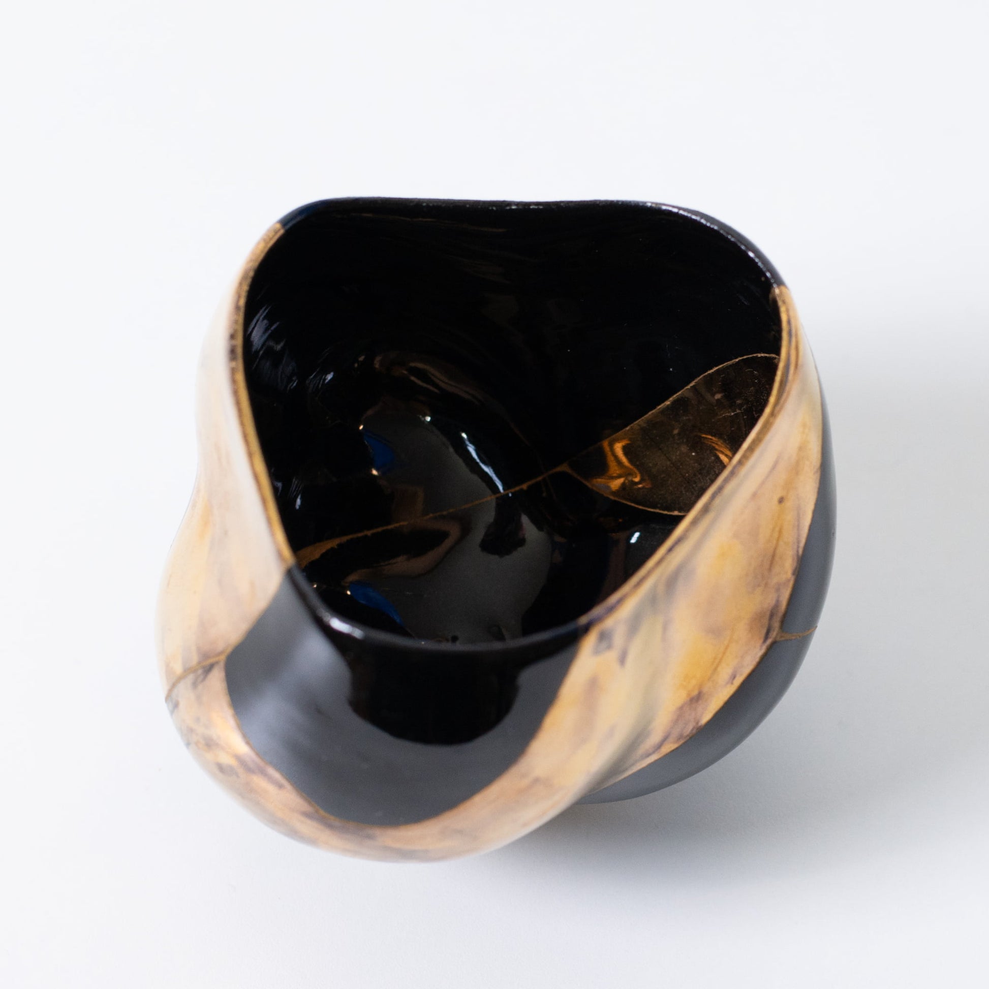 Vue de dessus d'un bol à matcha japonais kintsugi représentant le wabi-sabi et la résilience