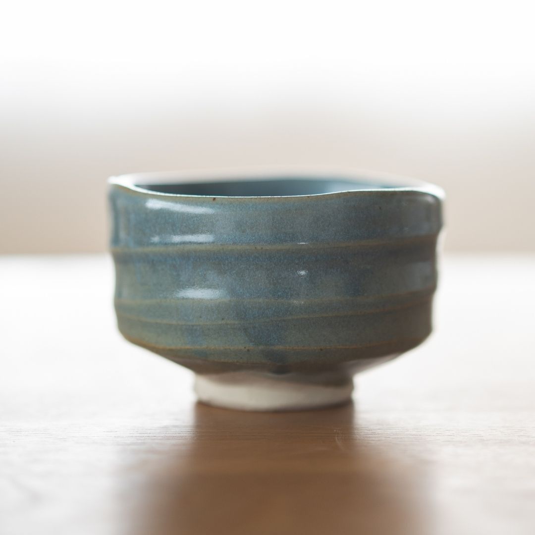 Centreret billede af den håndlavede "Summer Sky" matcha-skål fra Shinzan Kiln, med en uregelmæssig, organisk kant og synlig hvid lerbase, der fremhæver dens japanske keramiske kunsthåndværk.