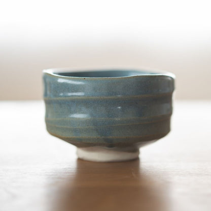 Centreret billede af den håndlavede "Summer Sky" matcha-skål fra Shinzan Kiln, med en uregelmæssig, organisk kant og synlig hvid lerbase, der fremhæver dens japanske keramiske kunsthåndværk.