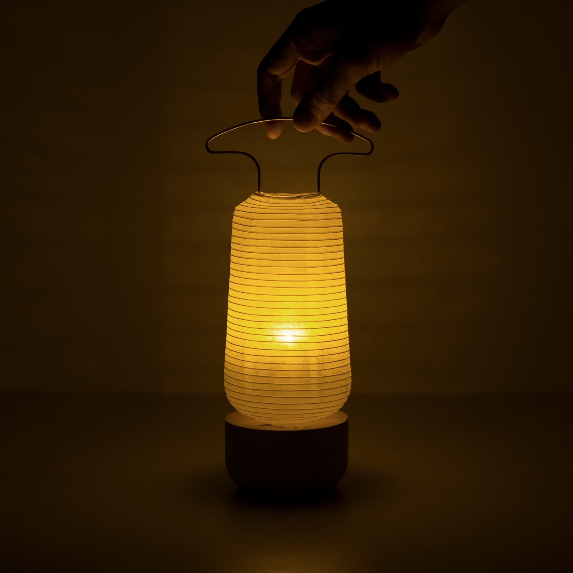 Een warm gloeiende traditionele Japanse papieren lantaarn in een donkere kamer