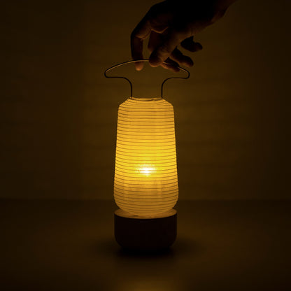 Een warm gloeiende traditionele Japanse papieren lantaarn in een donkere kamer