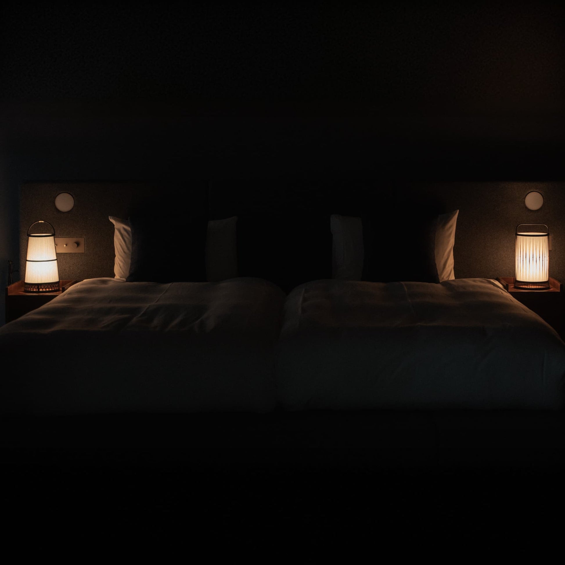 "Deux lampes de sol traditionnelles japonaises en bambou, fabriquées à la main à Shizuoka, illuminent une chambre de style Japandi."