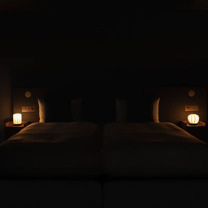 Japanse papieren tafellamp "Bloem van Licht M" op een houten nachtkastje