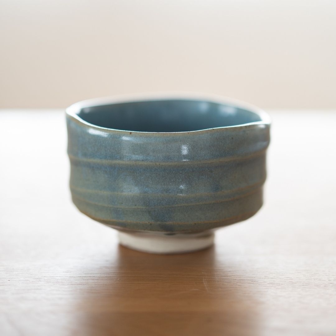 Detaljeret visning af "Summer Sky" japansk matcha-skåls eksteriør, med fokus på den ru, wabi sabi-keramiske tekstur og hvordan den blå glasur bliver tyndere over lerets riller.