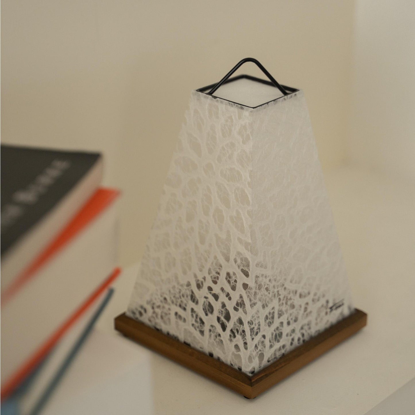 Close-up of unlit Japanese paper table lamp "Mini Akari" White, showing intricate lace patterns for Japandi decor.