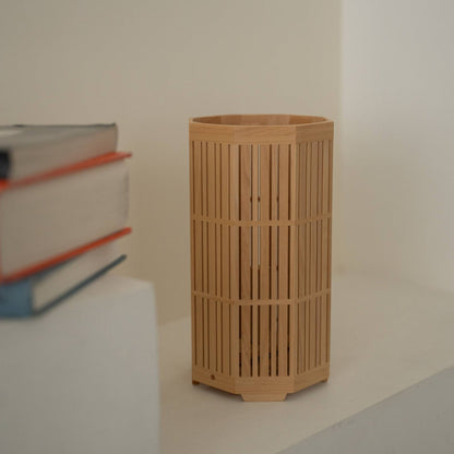Close-up of Japanese wood table lamp "Kagayaki" showcasing detailed Kumiko woodworking on the white console in a Japandi style room.