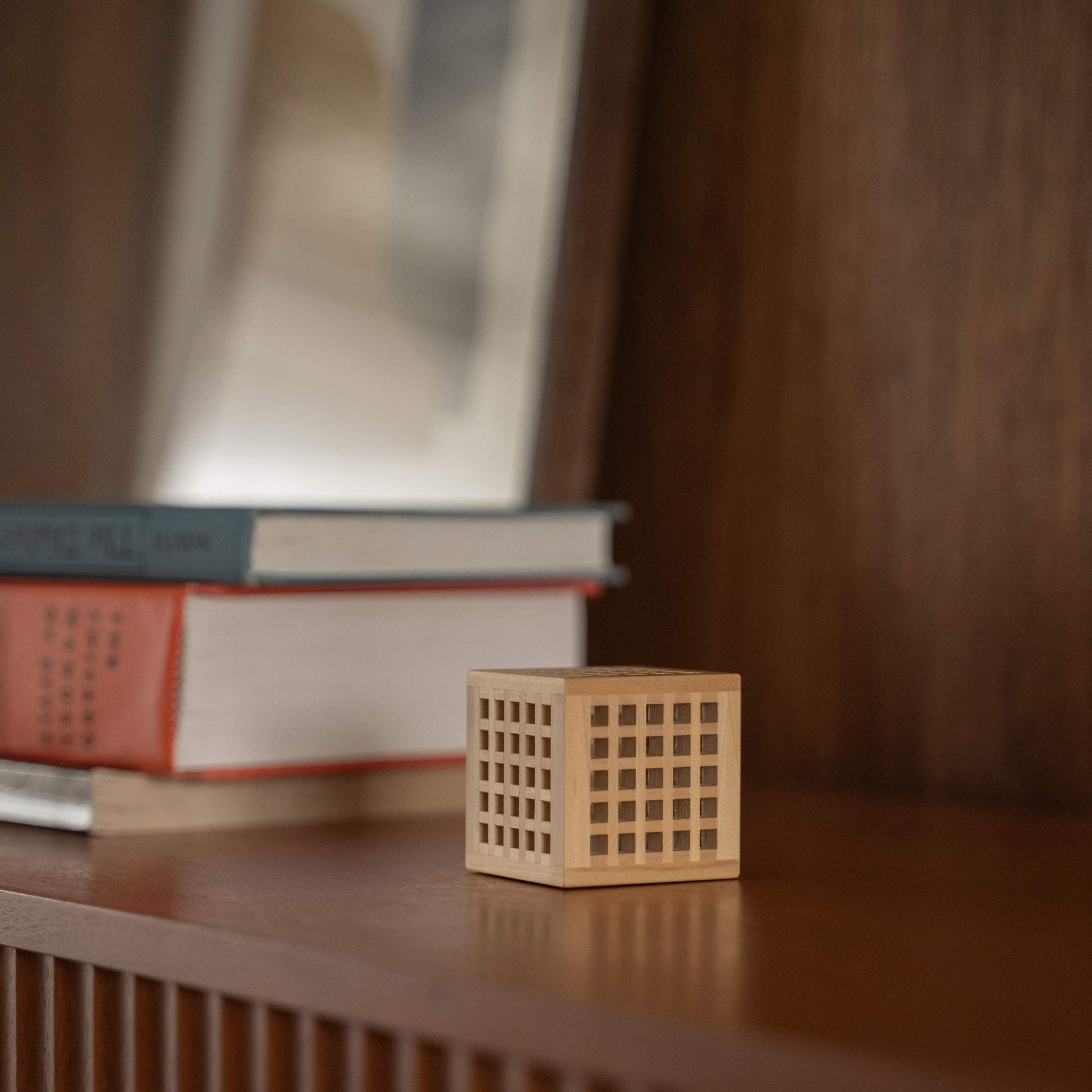 Unbeleuchtete japanische Mini-Holzlampe "Hotaru" mit detaillierter Kumiko-Holzarbeit als japanische Tischlampe auf einem Holzregal.