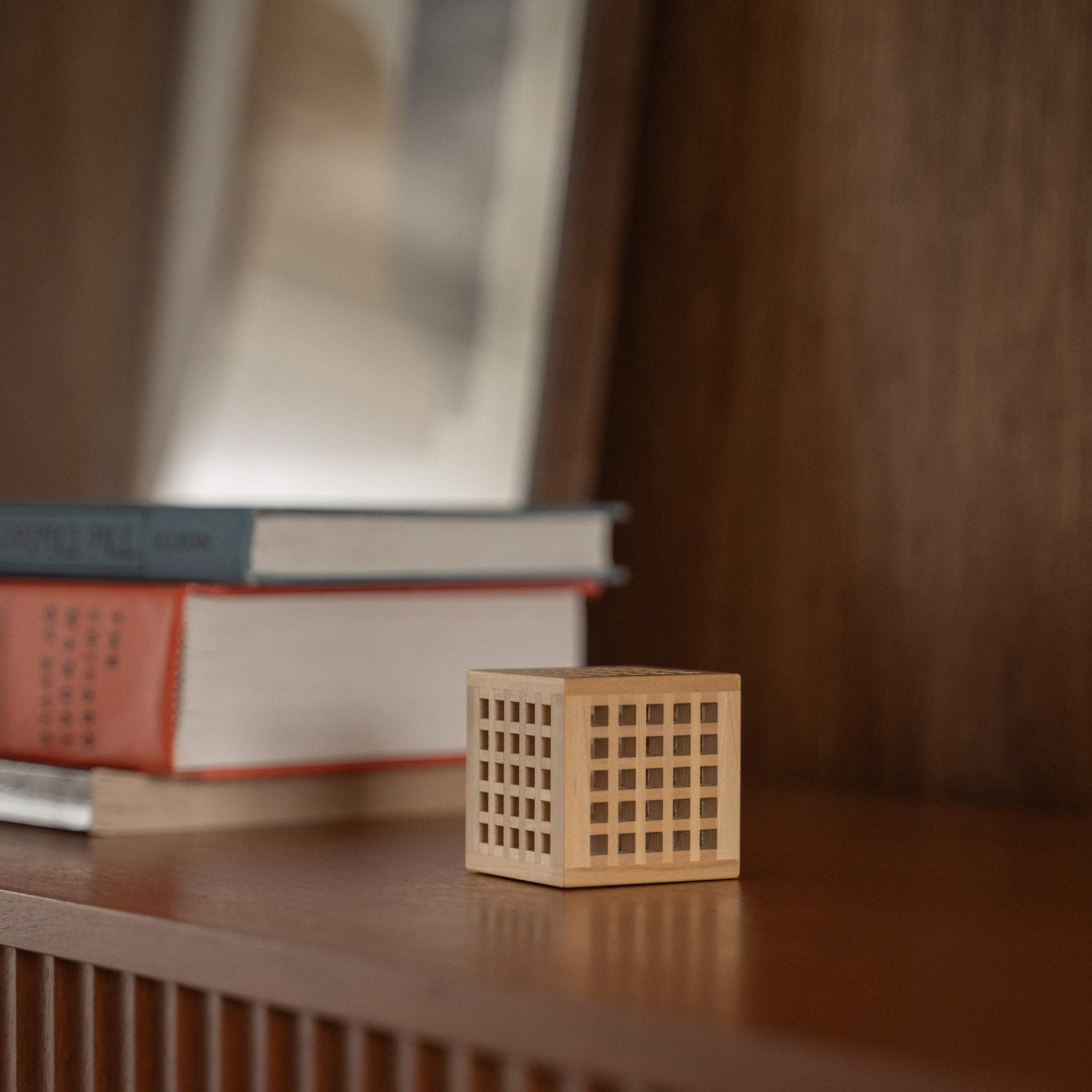 Unbeleuchtete japanische Mini-Holzlampe "Hotaru" mit detaillierter Kumiko-Holzarbeit als japanische Tischlampe auf einem Holzregal.