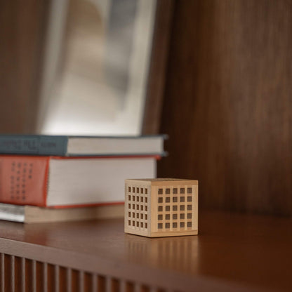 Unbeleuchtete japanische Mini-Holzlampe "Hotaru" mit detaillierter Kumiko-Holzarbeit als japanische Tischlampe auf einem Holzregal.