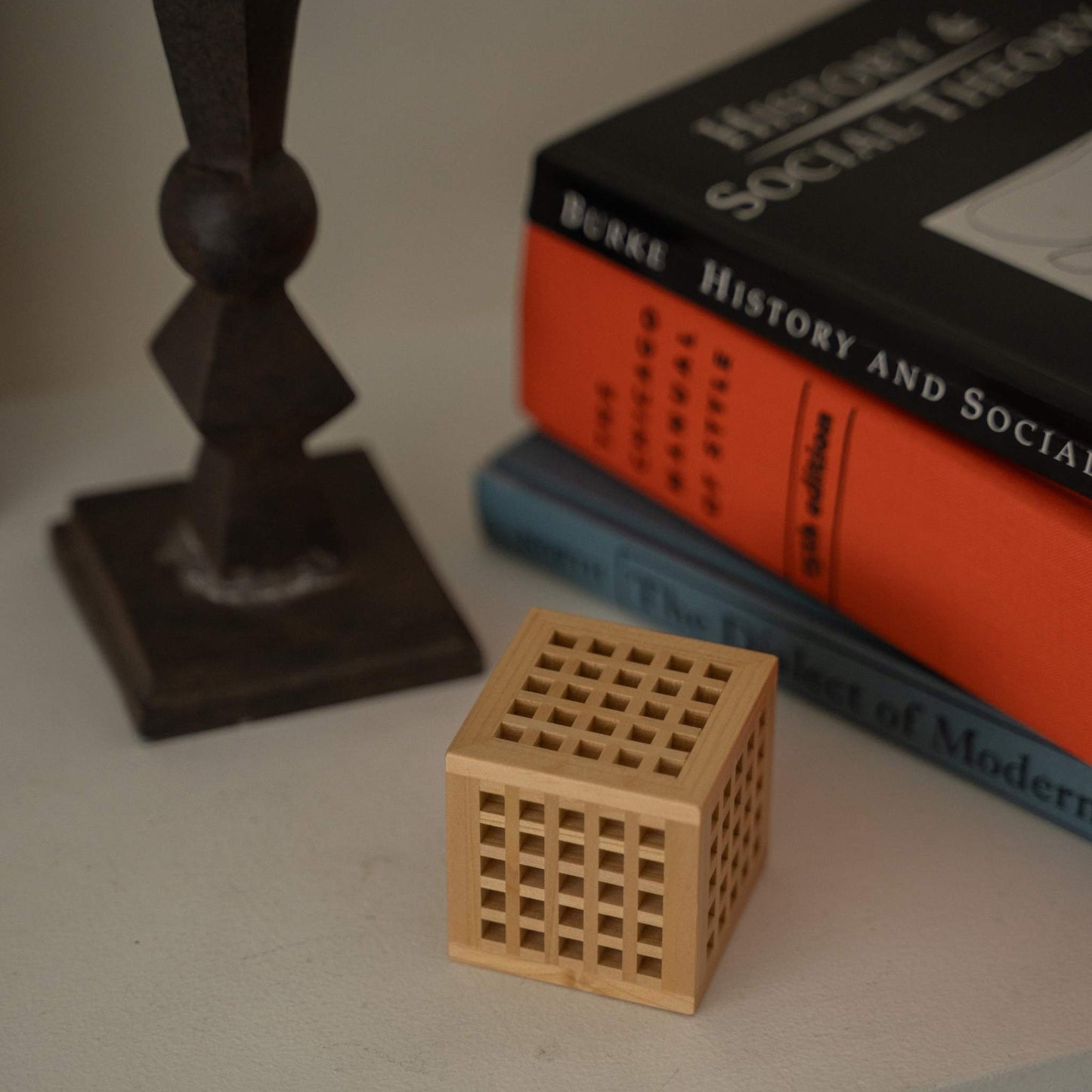 Japanische Mini-Holzlampe "Hotaru" mit filigraner Kumiko-Holzarbeit neben Büchern als einzigartige japanische Dekoration