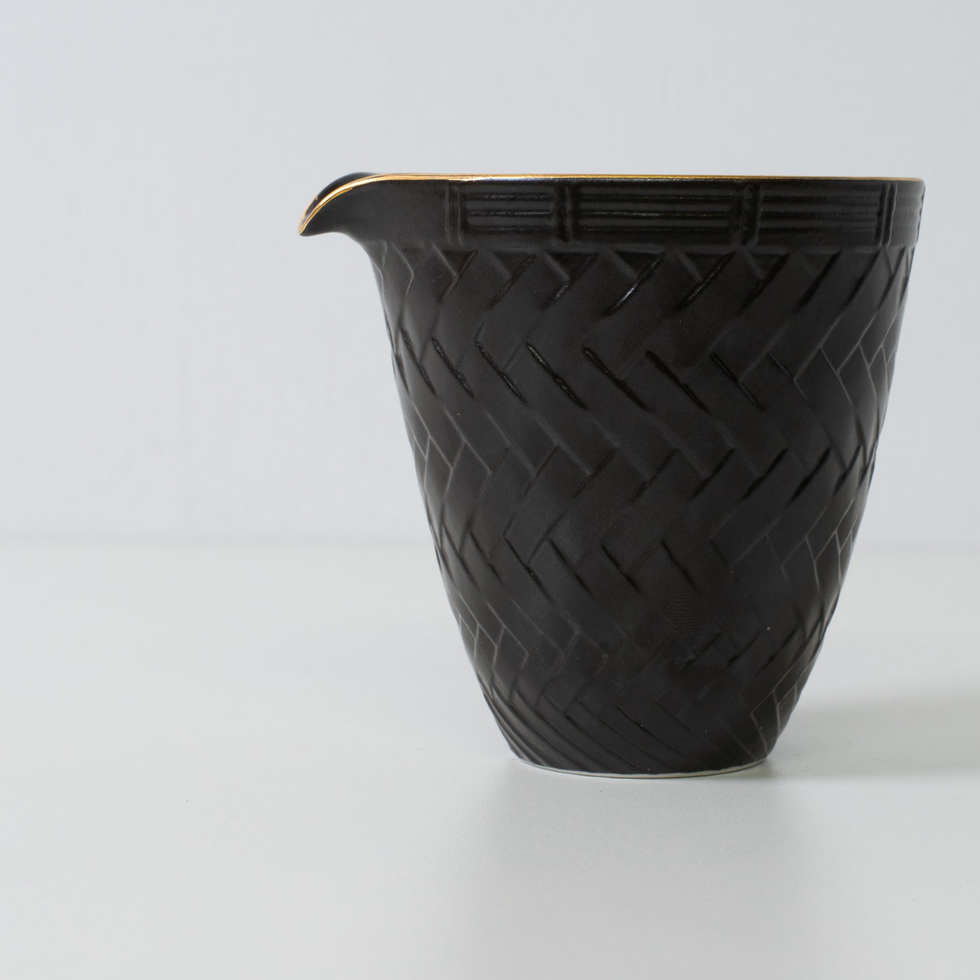Basket weave sake carafe, black porcelain - Close up of a Japanese sake carafe highlighting the woven texture