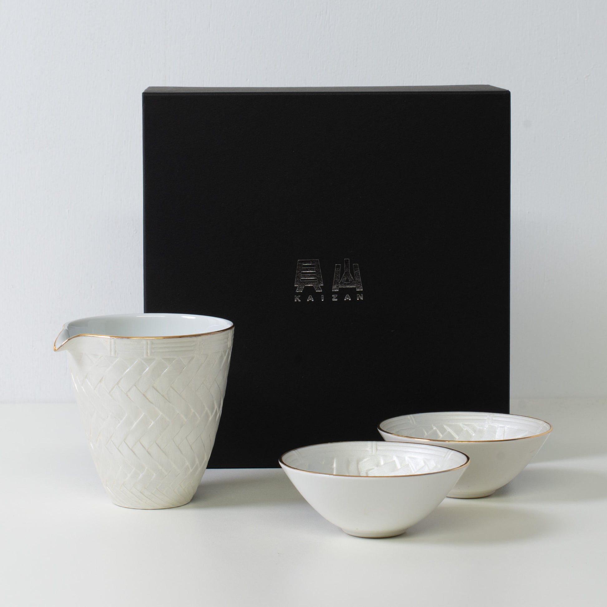 Sake-Set mit Korbgeflecht-Optik, weißes Porzellan – Japanische Sake-Karaffe und Sake-Becher in schwarzer Geschenkbox