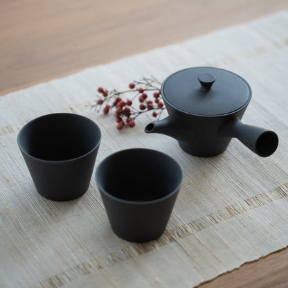 Schwarzes japanisches Teeset "Sencha" auf einer Leinematte für Minimalisten, die ein ruhiges tägliches Teeritual genießen.
