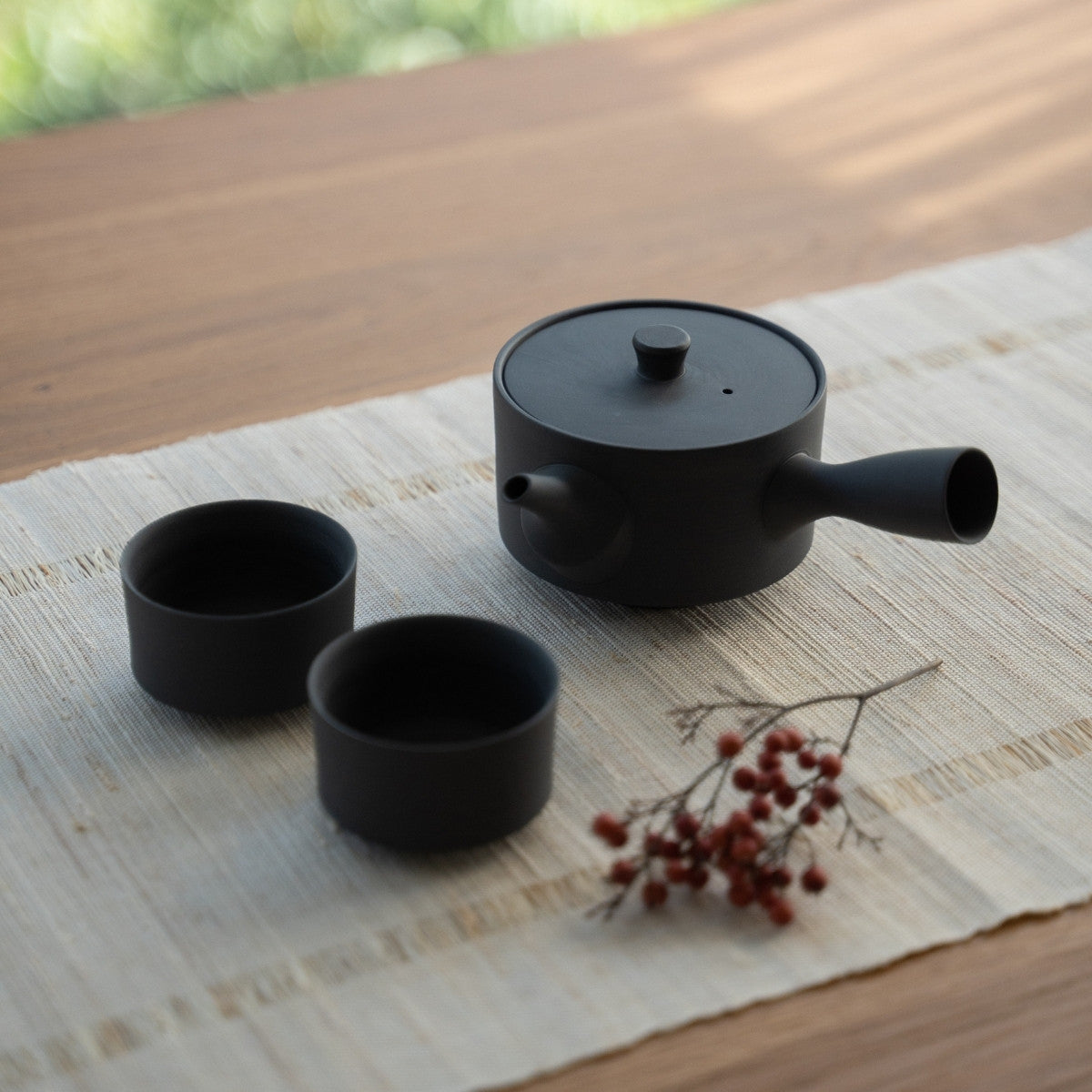 Black Japanese tea set "Sencha" with a wide kyusu on a sunlit table for minimalists preparing a sleek daily wellness ritual.