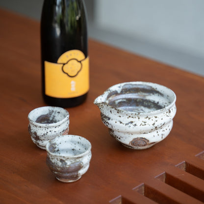 Zui uneven white Japanese sake set, carafe and cups on a dining table, to bring elegance to special dinners with guests