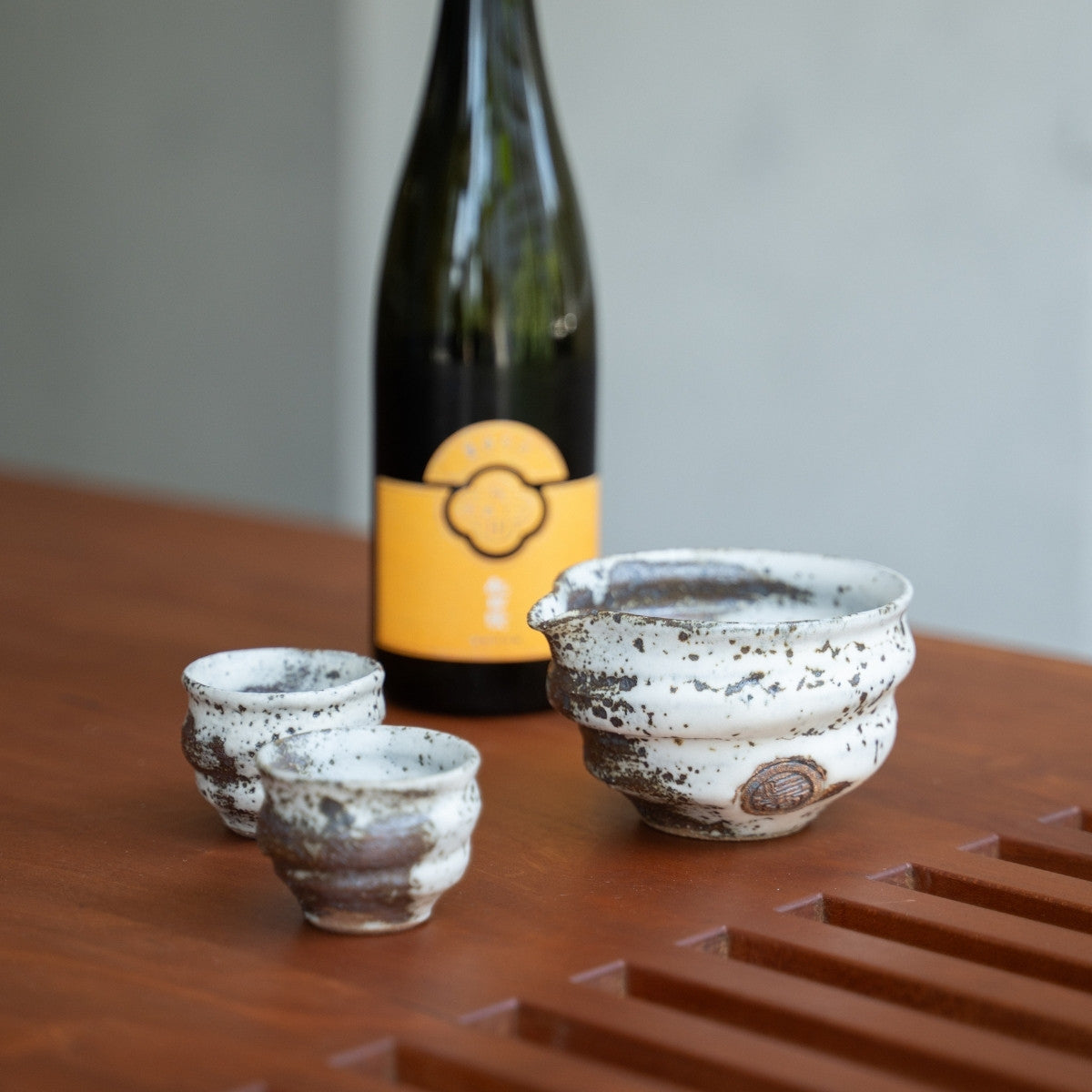 Zui uneven white Japanese sake set, carafe and cups on a dining table, to bring elegance to special dinners with guests