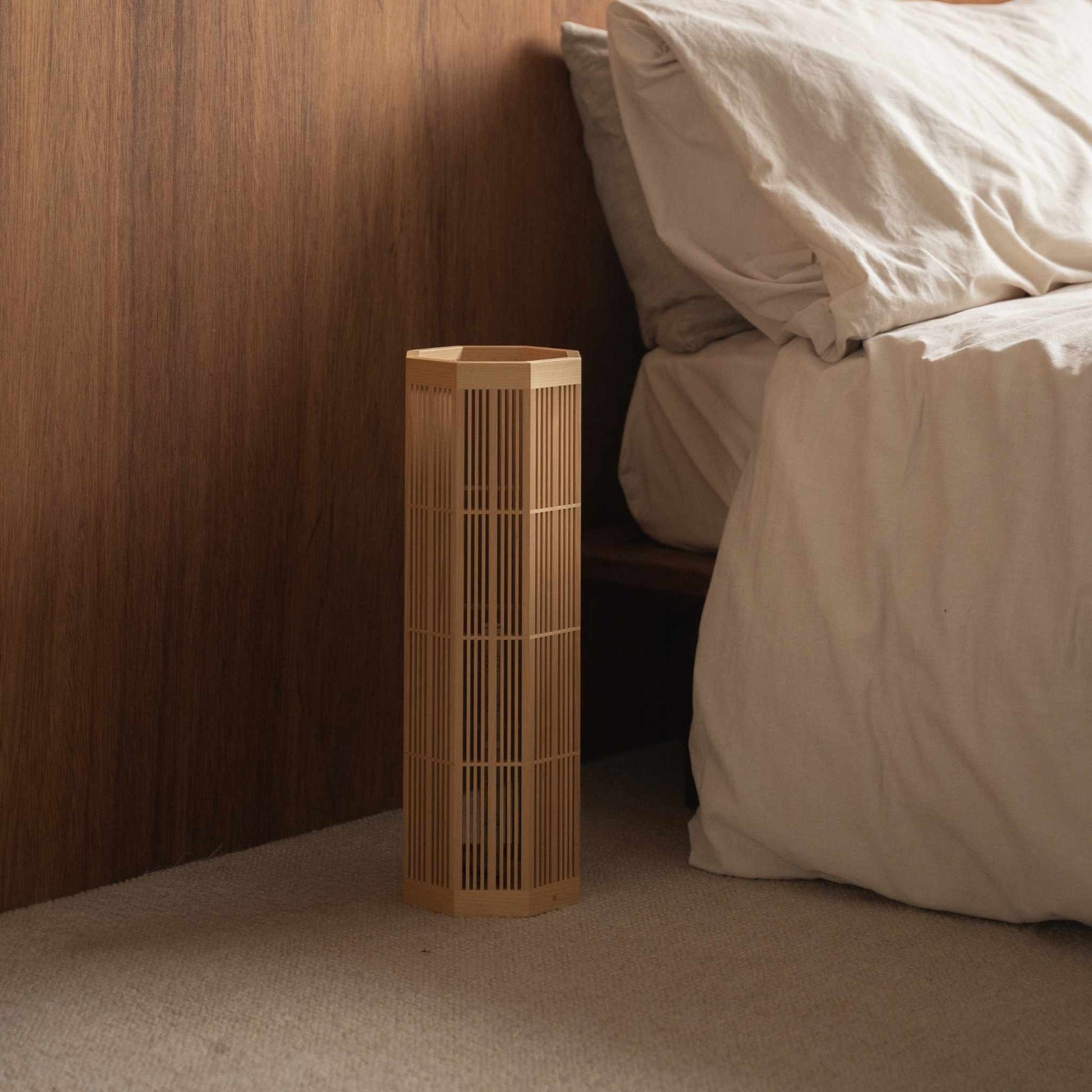 "Lampadaire japonais "SAN" non allumé, grand, debout comme lampe de décoration Japandi sur le sol d'une chambre."