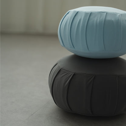 Calm blue and charcoal grey Japanese meditation cushion zafu, stacked in a modern space for a peaceful zen practice.