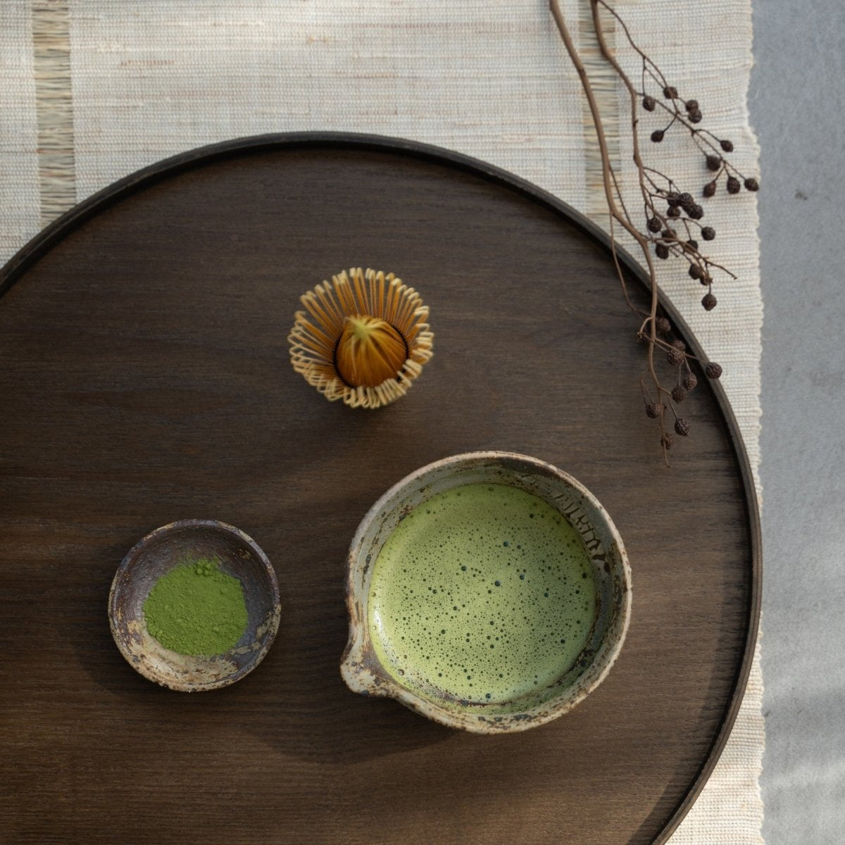 Japansk matcha-skål med tud på en træbakke til et roligt te-ritual med pisket grøn te.
