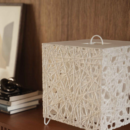"Lampe japonaise blanche en forme de cube en papier Me Look 03, posée éteinte sur une console en bois près d'un arrière-plan de lit."
