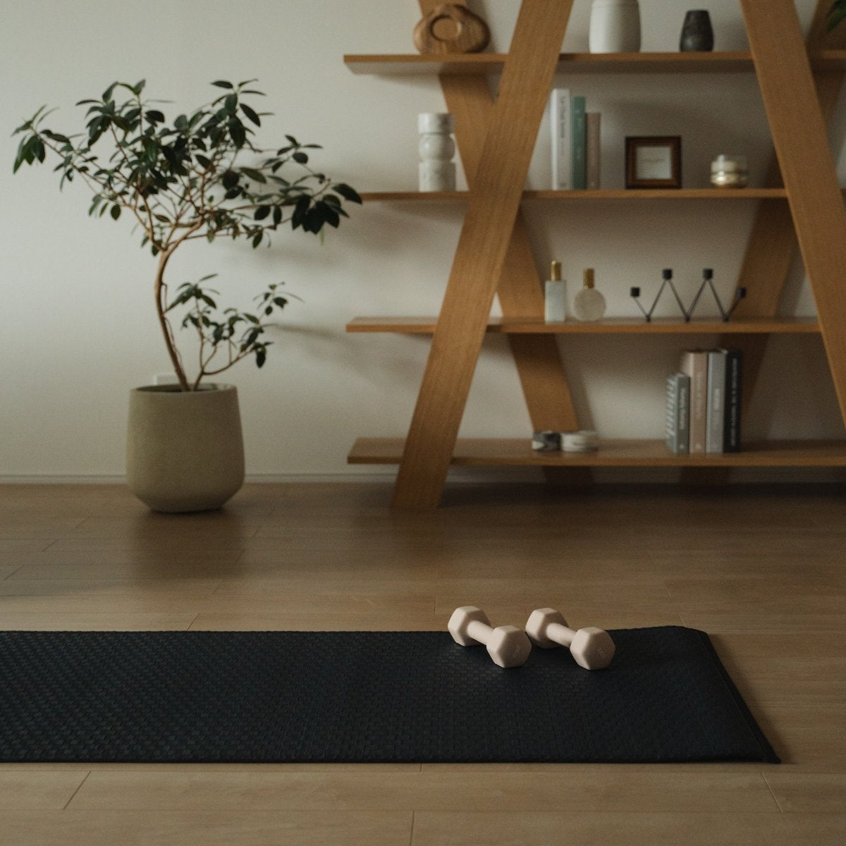 Japanse Tatami Yoga Matras "Ed Plain" Navy met dumbbells in een minimalistische Japandi woonkamer voor dagelijkse yoga routines thuis.