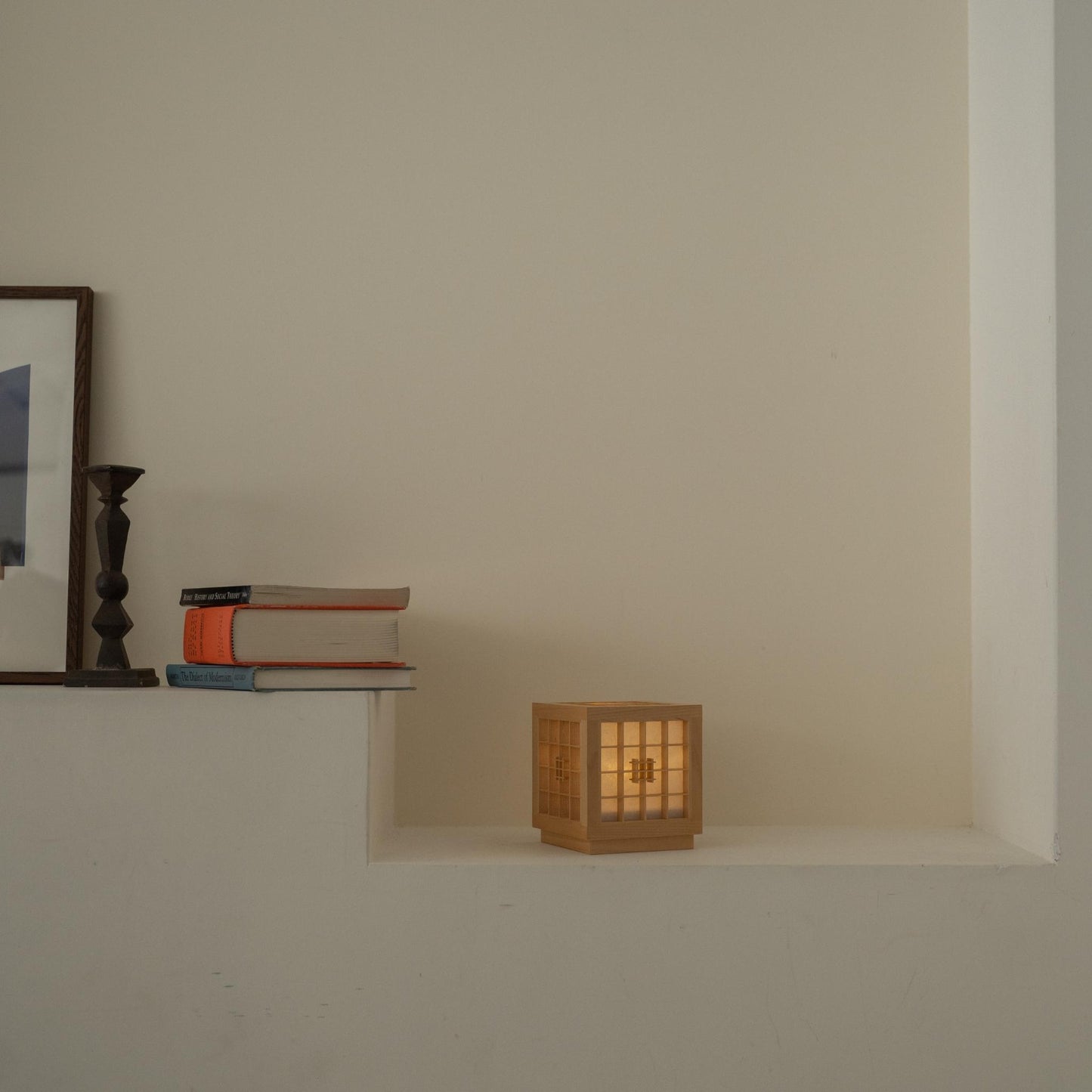 Lit Japanese Wood Table Lamp "Honoka" glowing on a white console table, acting as a warm ambient lamp for relaxation.