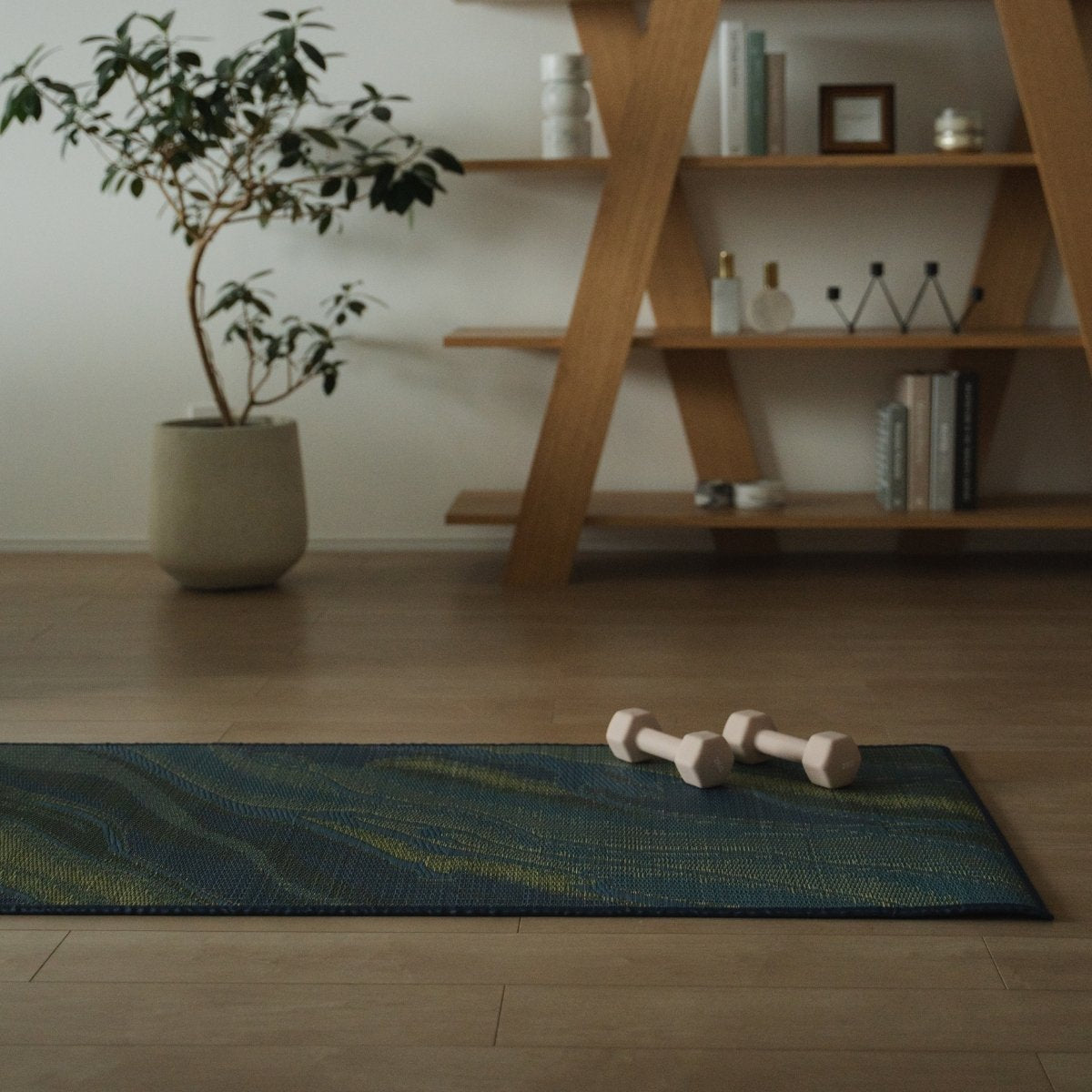 Japanese Tatami Yoga Mattress "Marble" Blue with dumbbells on a wooden floor in a stylish Japandi-style mindful space.