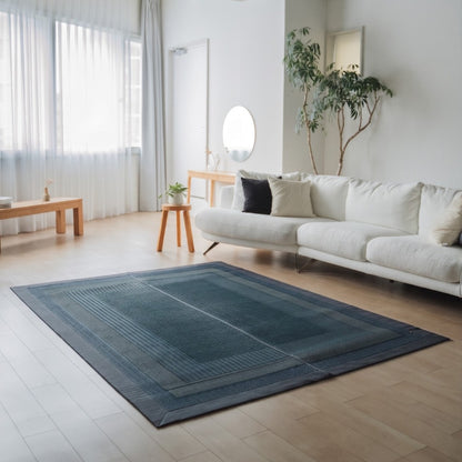 Japanse Tatami vloerkleed "Ranks" Indigo Navy op een houten vloer in een lichte woonkamer voor ruime, bewuste ontspanning.