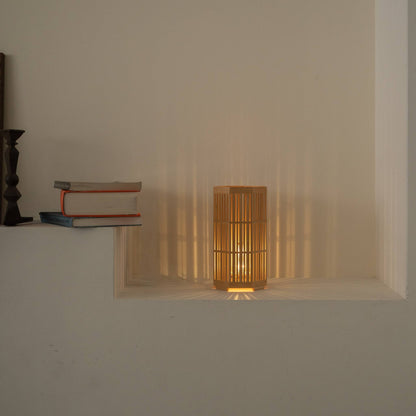 Lit Japanese wood table lamp "Kagayaki" casting beautiful radial shadows as a wabi sabi accent lamp in a Japandi living room.