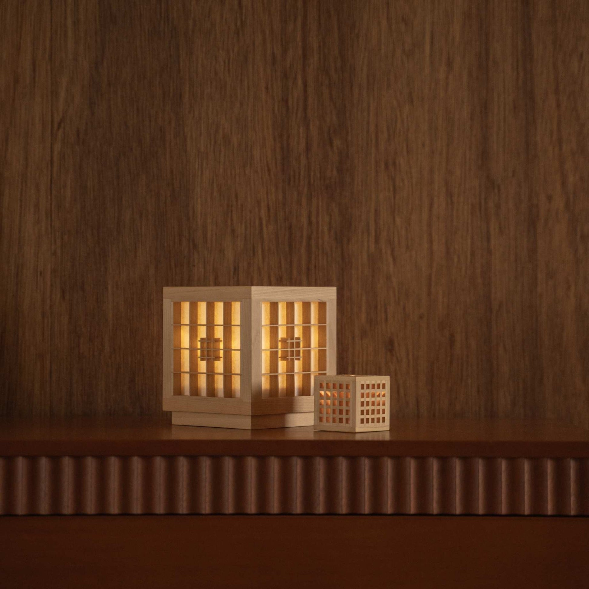 Lit Japanese wood table lamp "Honoka" and "Hotaru" glowing as ambient lamps on a mid-century modern console table.