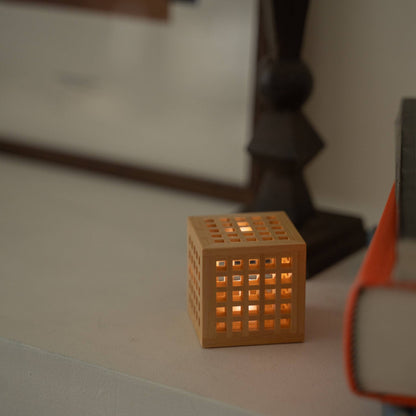 Lit. Japanische Holz-Mini-Lampe "Hotaru", die einen warmen Schein als gemütliche japanische Tischlampe auf einem Wohnzimmer-Konsolentisch abgibt.