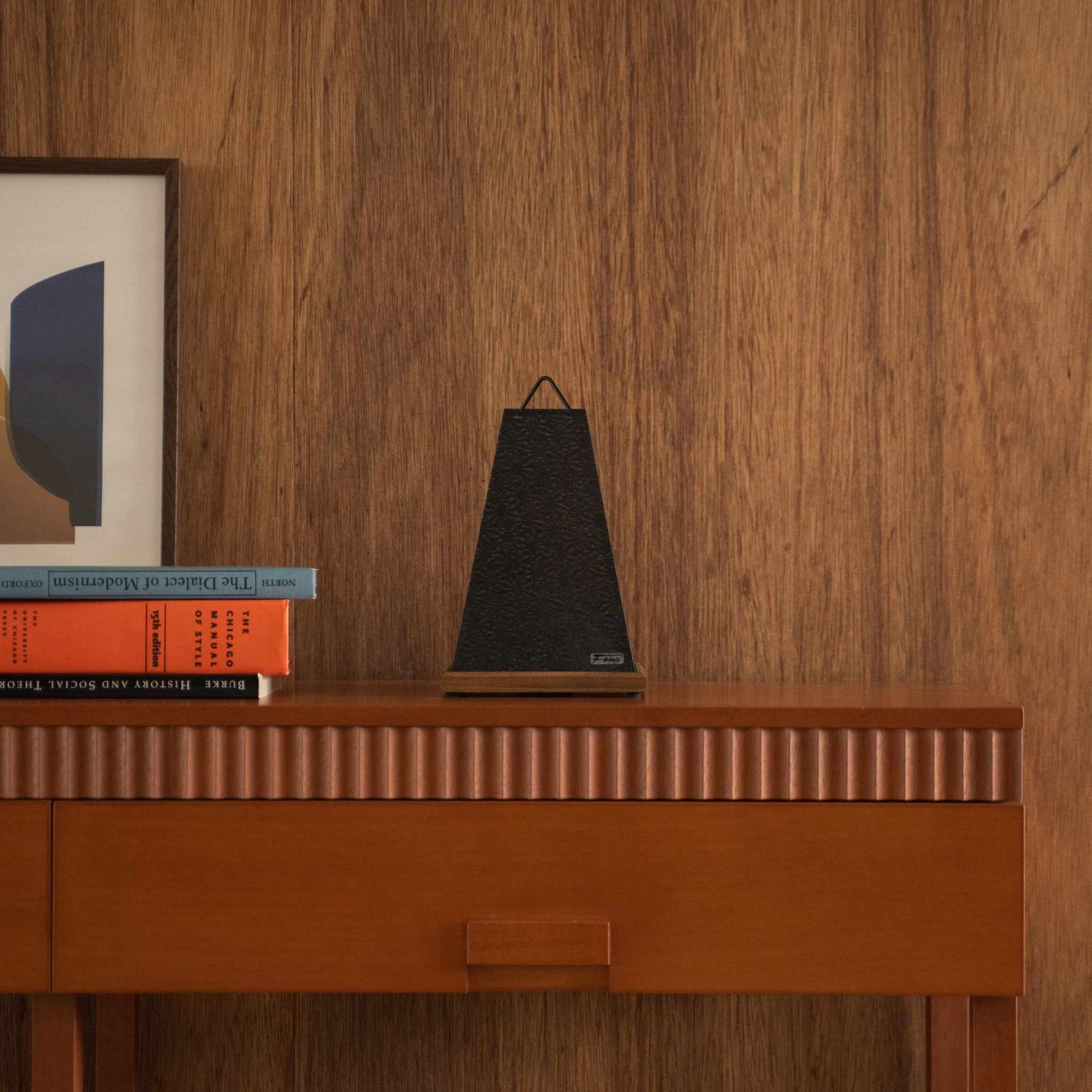 Unlit Japanese paper table lamp Mini Akari Black styled on a mid-century modern wooden console table with books.