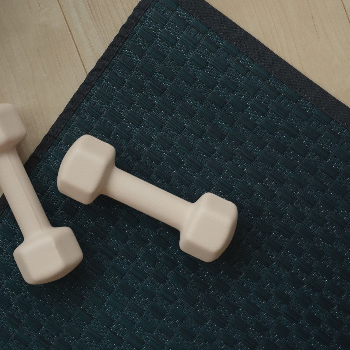 Gedetailleerde weving van de Japanse Tatami Yoga Mat "Ed Plain" Navy met dumbbells, die de strakke minimalistische grastextuur toont.