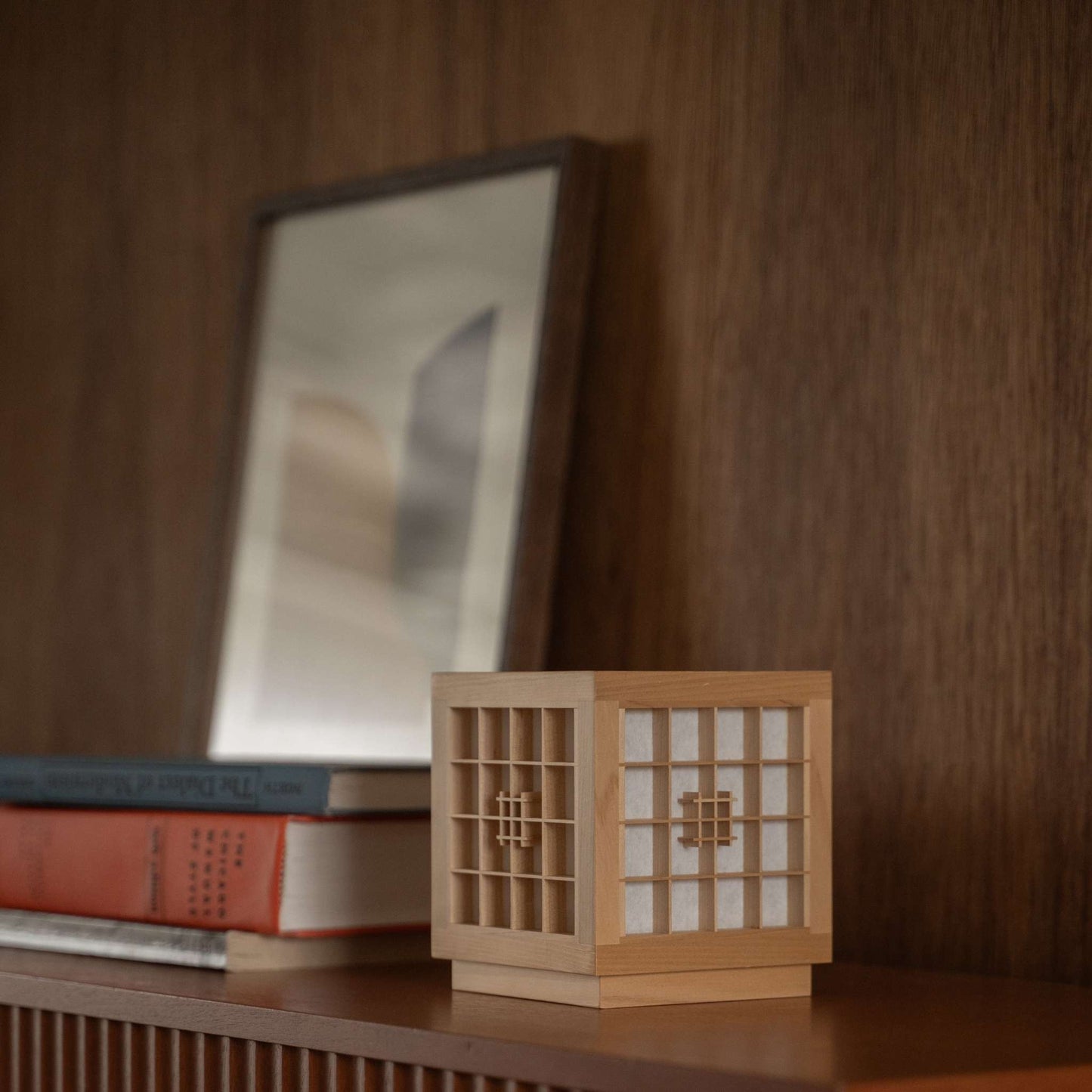 Japanese Wood Table Lamp "Honoka" used as a handcrafted wabi sabi accent lamp on a wooden shelf in a mid-century-modern room.