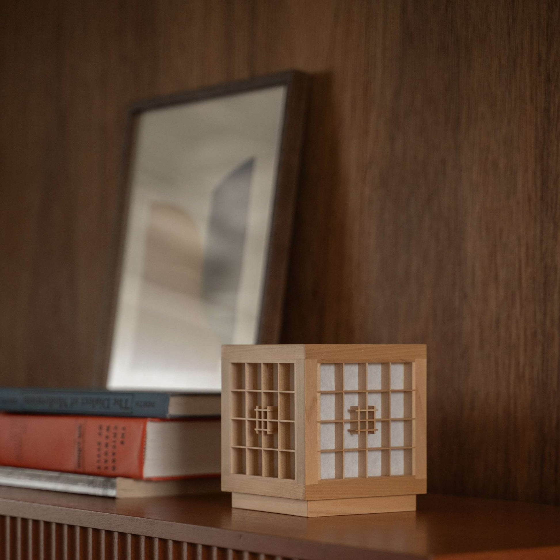 Japanese Wood Table Lamp "Honoka" used as a handcrafted wabi sabi accent lamp on a wooden shelf in a mid-century-modern room.